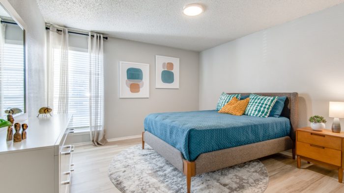 a bedroom with a blue bed and a white dresser at The 8500 Harwood